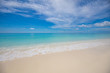 Summer beach and sea. Tropical pattern with blue sky and calm waves splashing. Exotic nature backdrop, coastline and beach