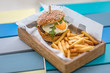 Tasty beef hamburger with fries in wooden box serving. Delicious gourmet food, special burger