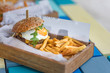 Tasty beef hamburger with fries in wooden box serving. Delicious gourmet food, special burger