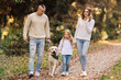 © zadorozhna - Happy family is having fun with dog labrador outdoors.