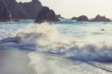 Wall Mural - Beautiful rocky beach and ocean wave under blue cloudy summer sky. California, USA