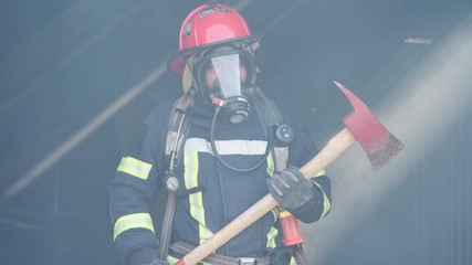 Wall Mural - Asian fireman holding Axe Standing confident. Fireman career concept. Slow motion.