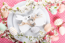 Easter Table Setting, Holiday Table Home Decor Idea, Flat Lay Composition With White Plates, Cutlery, Colorful Pastel Painted Easter Eggs, Festive Decor And Fresh Spring Flowers