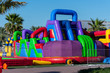 © KingmaPhotos - VIbrant and bright colored children's blow up playground with slides and bouncy castle  at a street festival for outdoor fun in summer.