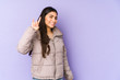 © Asier - Young indian woman isolated on purple background showing a horns gesture as a revolution concept.