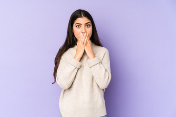 Wall Mural - Young indian woman isolated on purple background shocked, covering mouth with hands, anxious to discover something new.