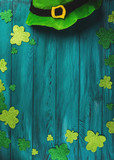Fototapeta Tulipany - St Patrick Day dark green wooden rustic background with shamrock and leprechaun costume hat