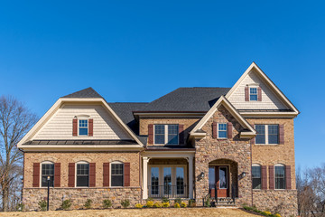 Front view of American luxury single family mansion with curb appeal with large double hung sash arch windows  dark bar shutters, covered entrance way, gable and gambrel roof in Maryland