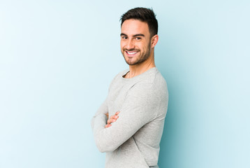 Wall Mural - Young caucasian man isolated on blue background happy, smiling and cheerful.