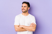 Young Caucasian Man Isolated On Purple Background Smiling Confident With Crossed Arms.
