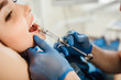Procedure teeth anesthesia. Teeth treatment without pain. Syringe with anesthesia near teeth. Cropped image.