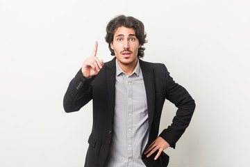 Young business man against a white background having an idea, inspiration concept.