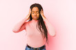 © Asier - Young african american woman isolated on a pink background touching temples and having headache.