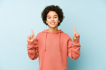 Wall Mural - African american little boy isolated indicates with both fore fingers up showing a blank space.