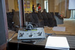 interpreting - Microphone and switchboard in an simultaneous interpreter booth . Soft focus of wireless Conference microphones and notebook in a meeting room.