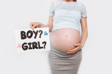 Image Of A Pregnant Woman Holding A Paper Near The Pregnant Belly, With A Boy Or Girl Issues