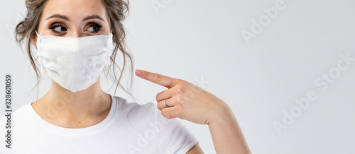 Cuadros en Lienzo Beautiful caucasian young woman in white t-shirt with disposable face mask