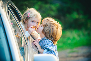 Gives warm kiss. Little boy say good bye with little girl. Farewell concept. Little girl says goodbye to little boyfriend who sails for long time. Funny little couple saying goodbye before car travel.