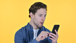 © stockbakers - Young Man with Loss on Smartphone, Failure on Yellow Background