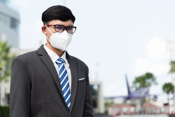 Close up of a businessman in a suit wearing Protective face mask and cough, get ready for Coronavirus and pm 2.5 fighting against in city background.