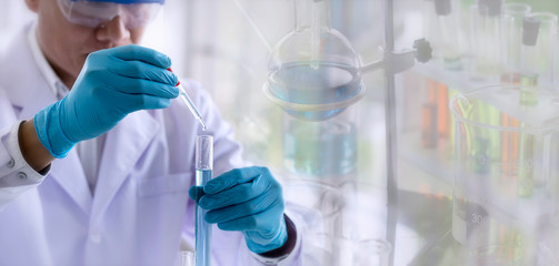 Wall Mural - laboratory research concept; scientist dropping chemical reagent into test tube. research in chemica