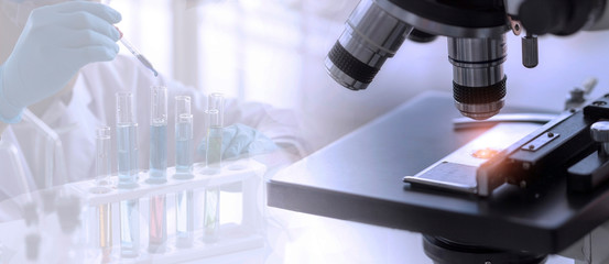 Wall Mural - laboratory concept; close up of microscope with a blurred picture of the scientist is researching in