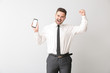 © Pixel-Shot - Happy businessman with mobile phone on light background