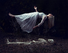Levitation Image Of A Woman Rising From A Skeleton On Dead Leaves