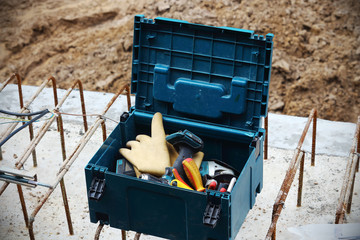 Open blue dirty tool box with various tools and gloves