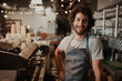 © StratfordProductions - Portrait of handsome young male coffee shop owner standing behind counter