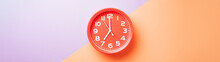 Red Clock Alarm Clock On Colored Background Divided Into Lilac And Beige Color Web Banner: Planning Or Working Time Concept