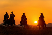 Cowboy Riding A Horse Carrying A Gun In Sunset With Mountain 