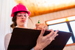© Valmedia - selective focus, low angle view of left handed female home inspector using a clipboard to take notes, reviews or reports about the house condition.