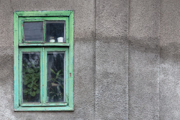 Wall Mural - Old gray wall with a green window.