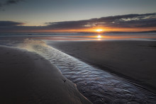 Last View Of The Sun As It Sets Over The Horizon On Aberavon Beach In Port Talbot, South Wales, UK