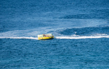 Speedboat People Tubing On The Blue Sea