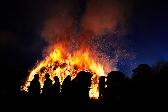 people standing in front of a traditional easter fire in germany
