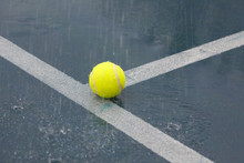 Yellow Tennis Ball On T Line On Rainy Tenis Court. Strong Rain Interrupted Tennis Match.
