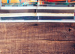 © Sondem - Top view of pile of different tabloid and overlayed magazines on wooden table. Background textures concept.