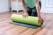 © yaophotograph - Close-up of attractive asian girl folding green yoga or fitness mat after working out at home in living room. Healthy life, keep fit concepts. Horizontal shot