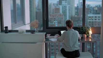 Wall Mural - back view of millennial female freelancer analyzing web information during time for e learning on mo