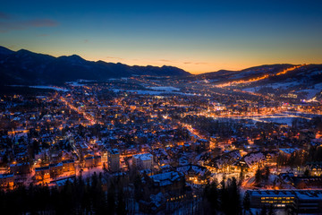 Wall Mural - Amazing illuminated Zakopane city in winter at night, aerial view