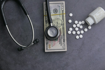 Wall Mural - top view of cash, coin and stethoscope on black background