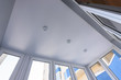 Stretch ceiling on a glazed balcony with plastic windows