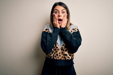 Sticker - Young beautiful woman wearing casual sweatshirt standing over isolated white background afraid and shocked, surprise and amazed expression with hands on face