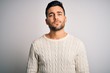 © Krakenimages.com - Young handsome man wearing casual sweater standing over isolated white background Relaxed with serious expression on face. Simple and natural looking at the camera.