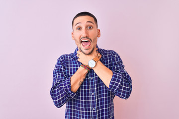 Wall Mural - Young handsome man standing over isolated background shouting and suffocate because painful strangle. Health problem. Asphyxiate and suicide concept.