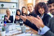 © Krakenimages.com - Group of business workers smiling happy and confident. Working together with smile on face looking at the camera applauding at the office