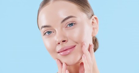 close up of beauty woman face looking at camera, isolated on blue background. beautiful female model