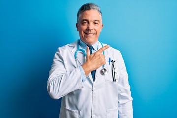 Poster - Middle age handsome grey-haired doctor man wearing coat and blue stethoscope cheerful with a smile on face pointing with hand and finger up to the side with happy and natural expression